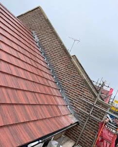 A red brick building with a red metal roof.