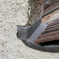 A close up of a gutter vent on a wall.