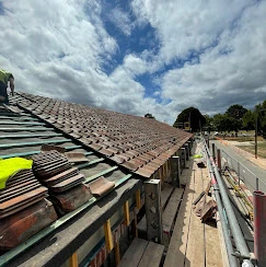 A man standing on top of a roof next to a building.