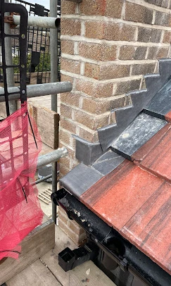 A red umbrella is hanging on a metal pole.