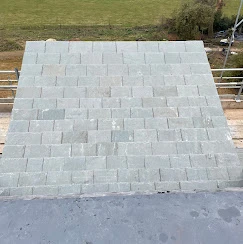 A man riding a skateboard on top of a cement ramp.